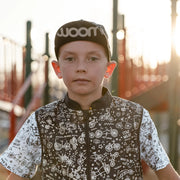 Woom FLARE Reflective Cap - Black hat on kid from front showing Woom logo