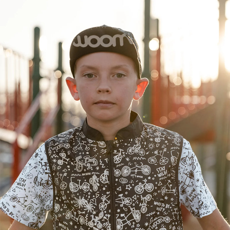 Woom FLARE Reflective Cap - Black hat on kid from front showing Woom logo